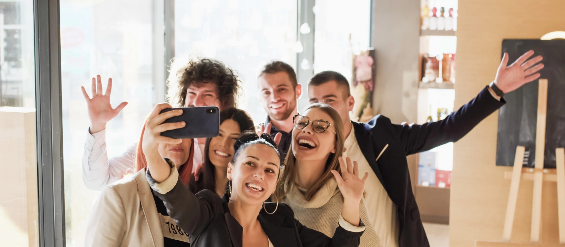 Gemischte Gruppe in Business Casual Outfits machen einen Selfie im Büro und lachen