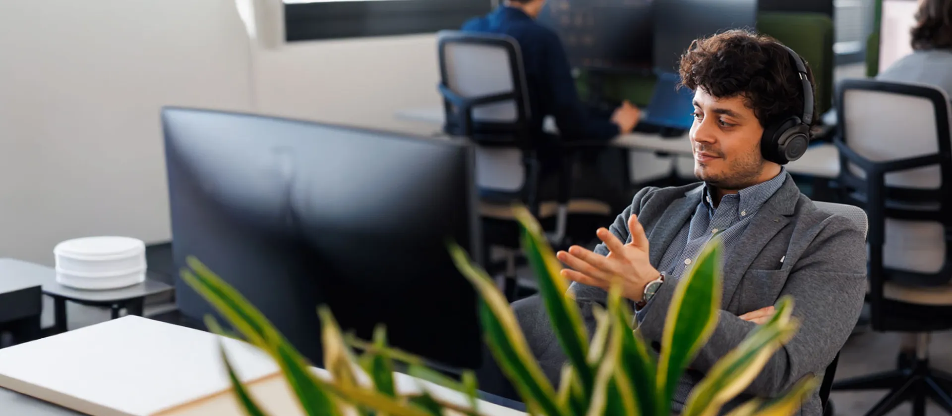 Man in modern office wearing headphones, engaged in a virtual meeting at msg Plaut, focusing on digital transformation and IT consulting.