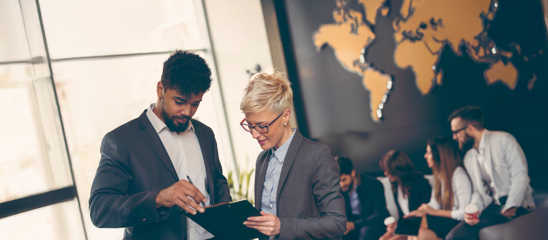  Businessmeeting mit internationalem Team vor Weltkarte 