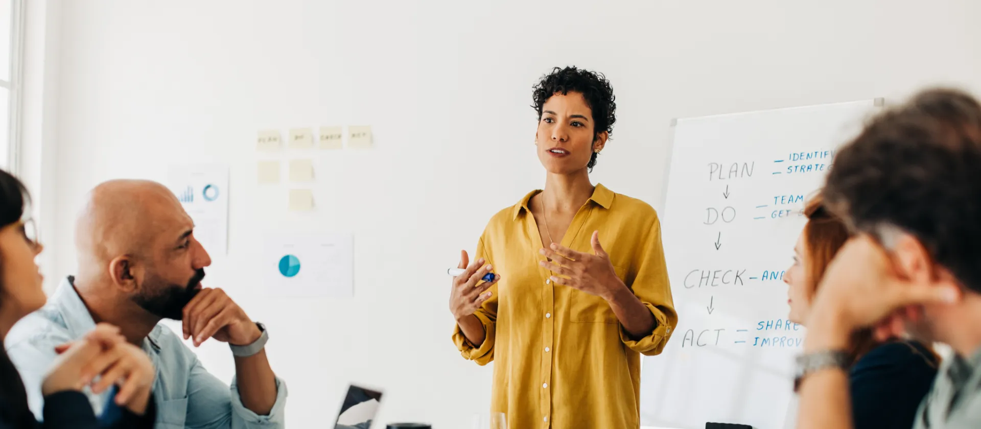 Mitarbeitende im Büro sitzen am Tisch und diskutieren ein Projekt