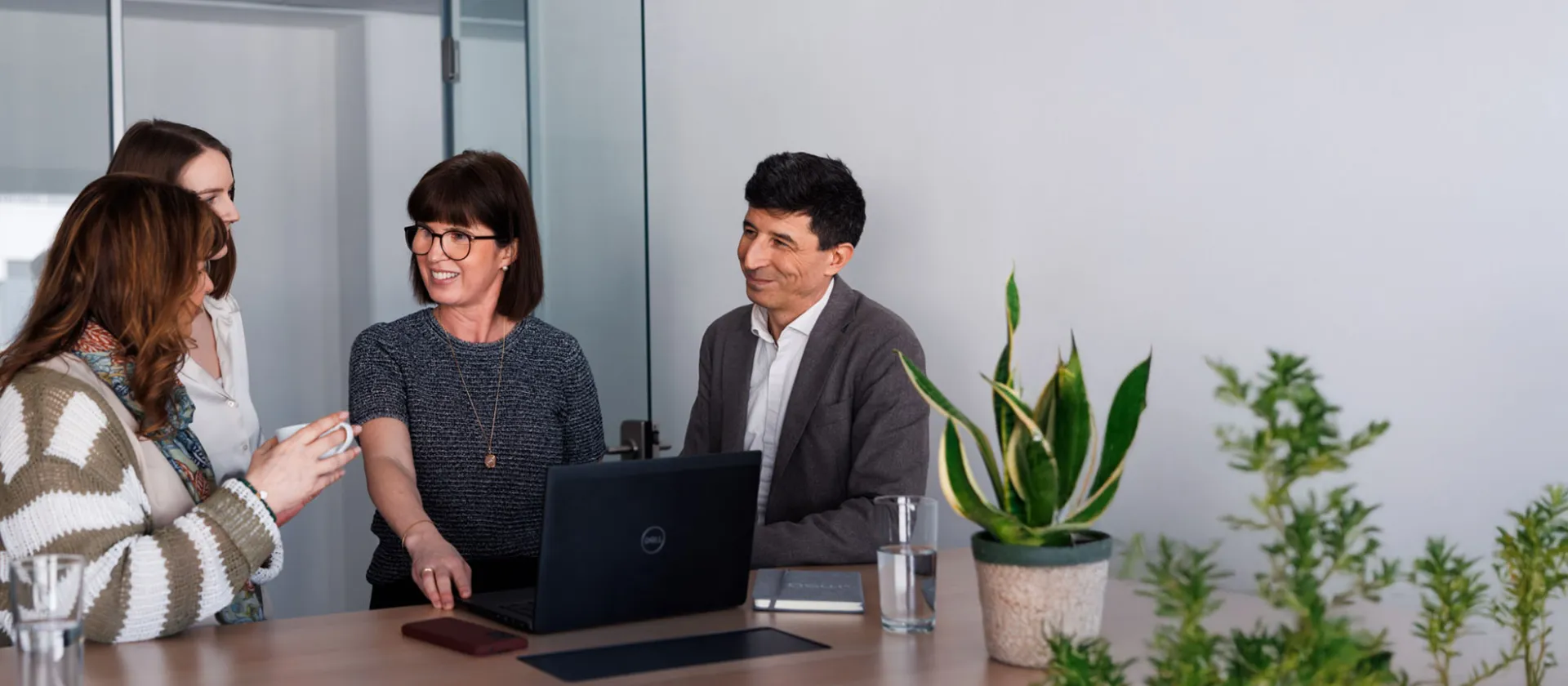 Business meeting with diverse team, discussing innovative digital solutions in a modern office setting.