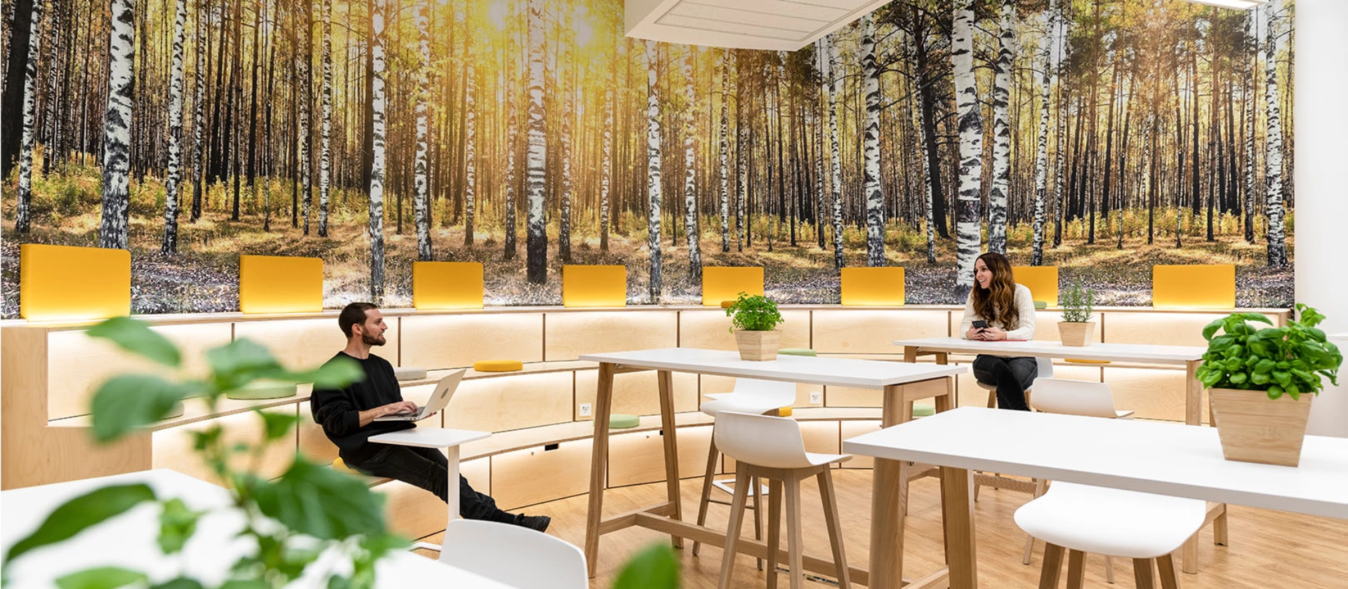 msg-Mitarbeitende auf den Sitzbänken in der Cafeteria am msg-Standort Frankfurt