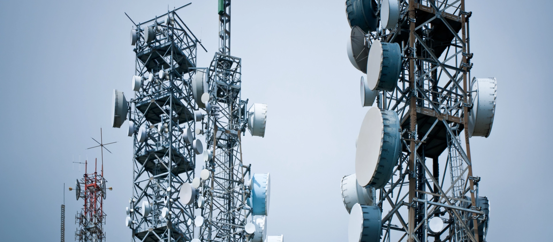 Arbeiter steht unter Strommasten