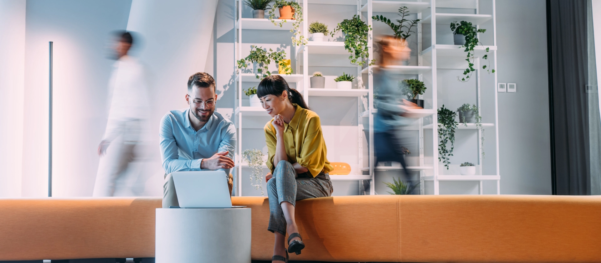 Ein Mann und eine Frau aus dem Bereich msg mobility advisors haben eine Besprechnung im Foyer auf einer Sitzbank