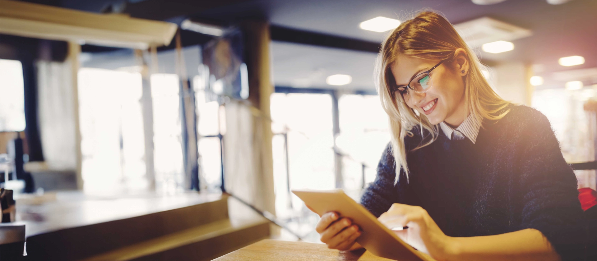 Eine Enduserin unserer msg digital services blickt zufrieden auf ihr Tablet