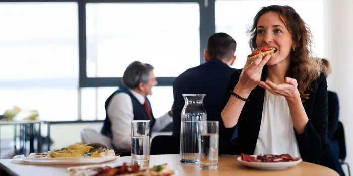 Professional woman enjoying lunch during an informal networking break at msg Plaut, reflecting the company’s focus on human-centered workplace culture