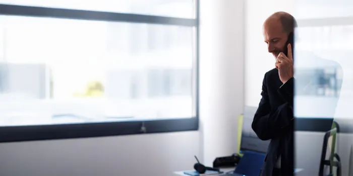 Business professional on a phone call in a bright office, reflecting msg Plaut’s expertise in strategic consulting and digital transformation.