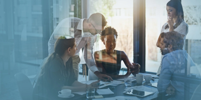 Eine gemischte Gruppe von Managern der Branche Utilities bespricht sich in einem Meetingraum