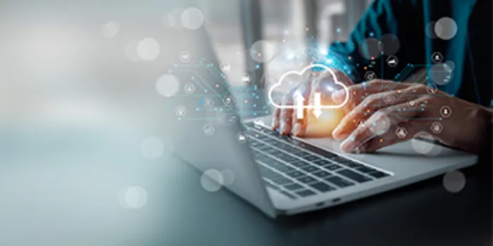 Hände tippen auf Laptop mit Cloud-Analytics-Symbol – steht für Datenanalyse in der Cloud.