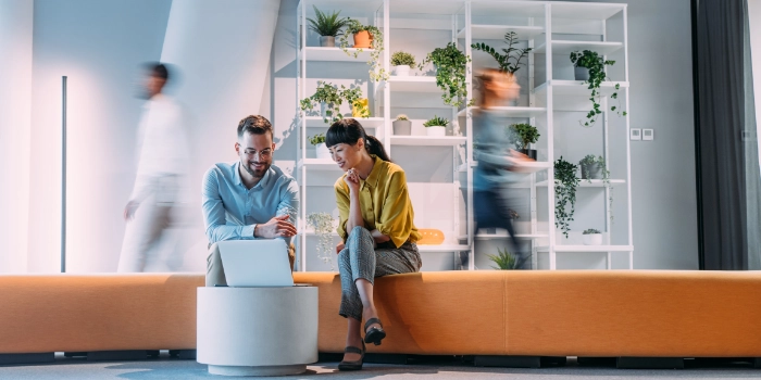 Ein Mann und eine Frau aus dem Bereich msg mobility advisors haben eine Besprechnung im Foyer auf einer Sitzbank