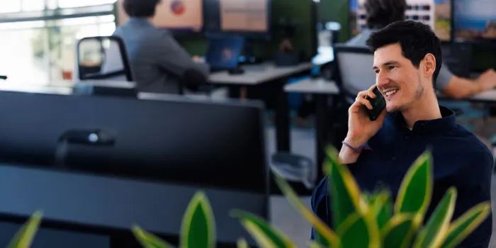 Smiling business professional on a phone call at modern msg Plaut office, collaborating on digital transformation solutions.