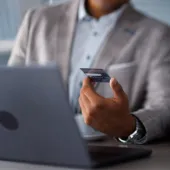 Close-up of two business professionals discussing digital payment and financial data using a laptop, symbolizing finance transformation and analytics in the SAP ecosystem.