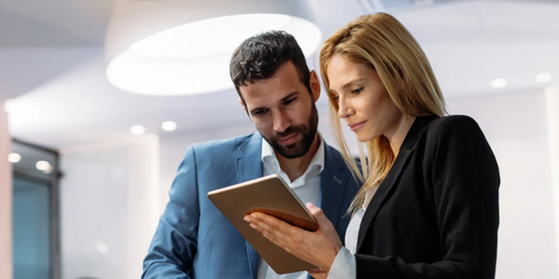Mann und Frau sehen sich Daten auf einem Tablet an