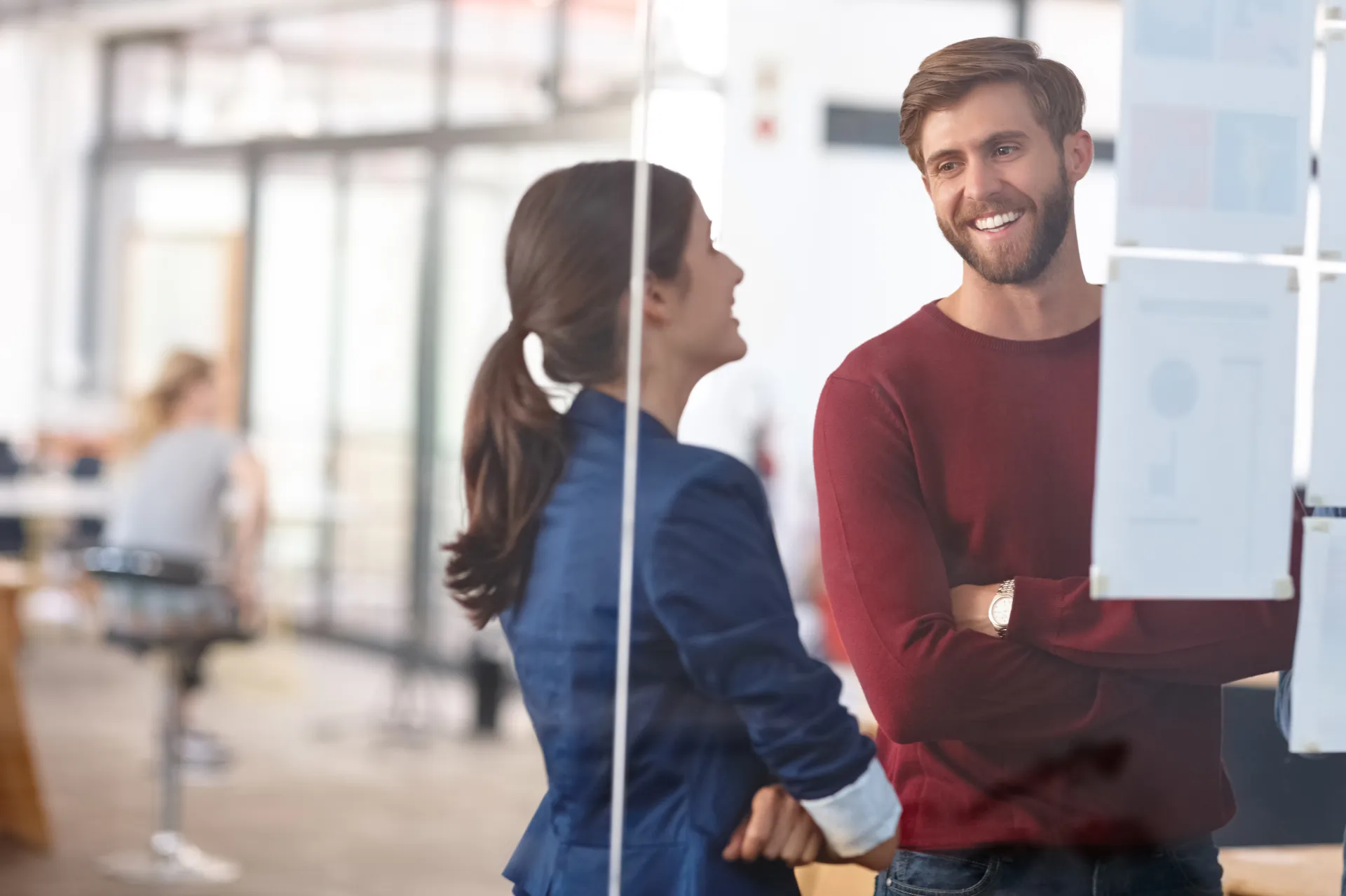 Zwei Mitarbeitende aus dem Geschäftsbereich Healthcare stehen vor einer Glaswand mit Notizen und unterhalten sich