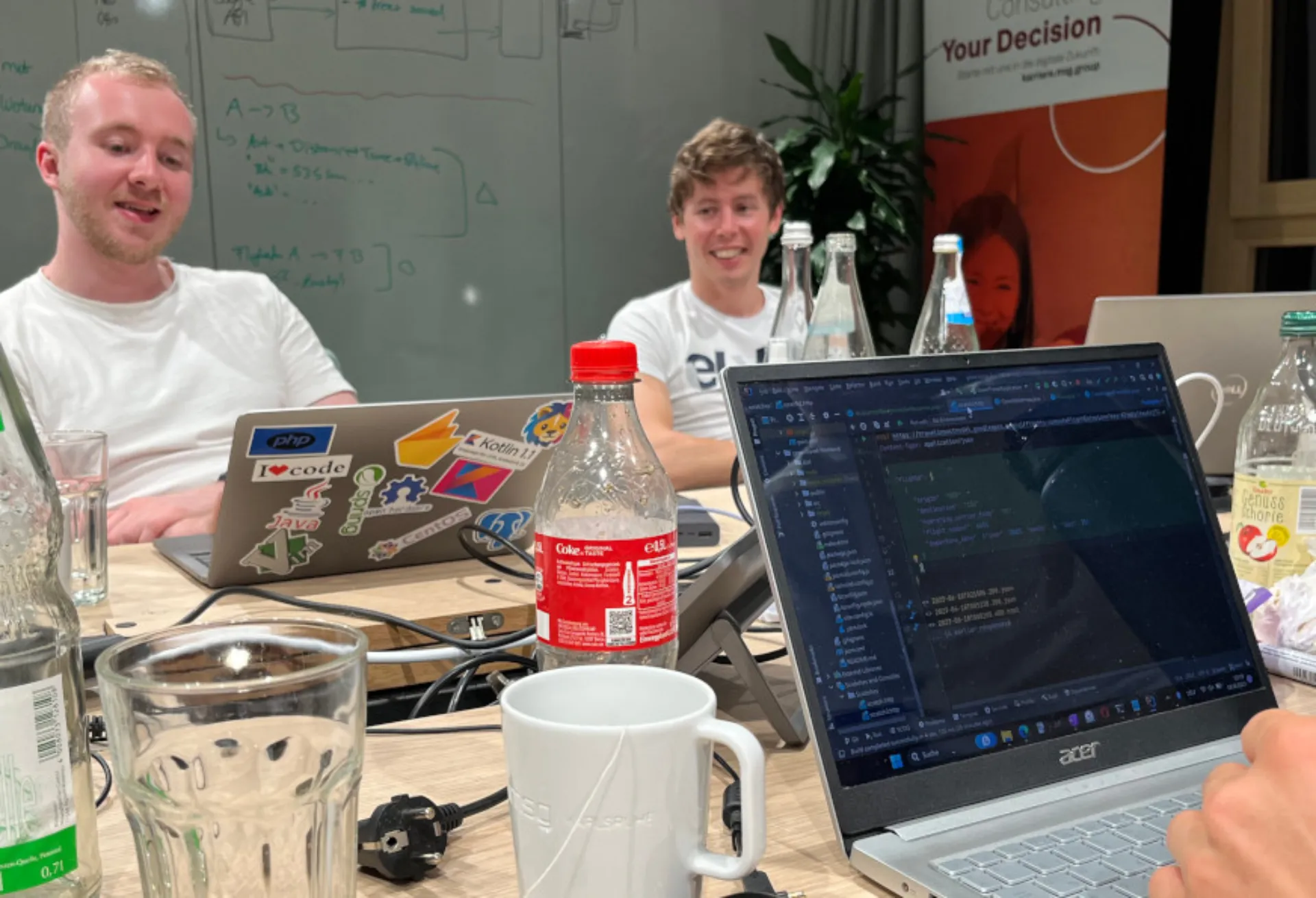Gruppe von Studierenden bei Code & Create Hackathon während des Codens an einem Tisch