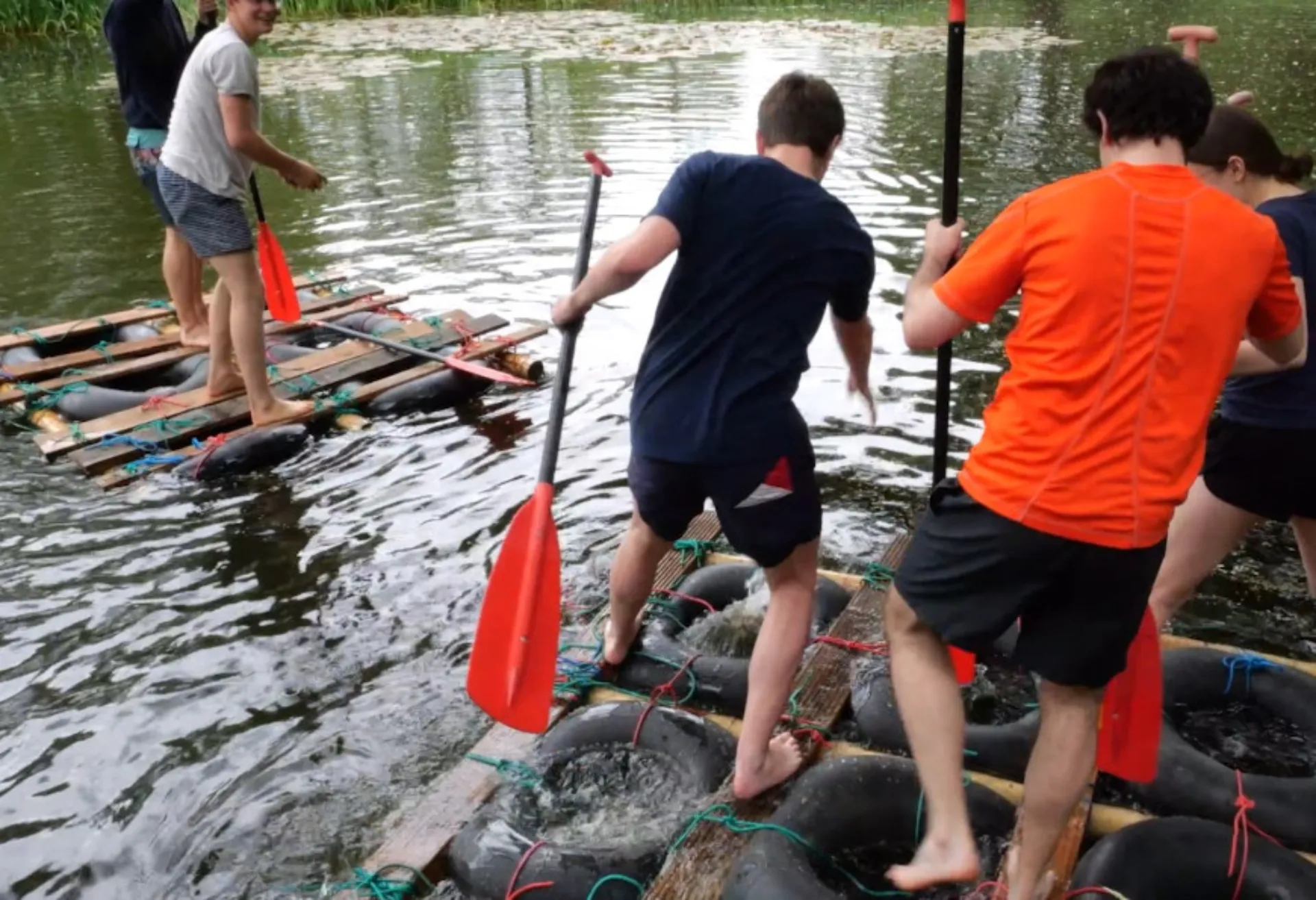 Teilnehmende Studierende während der Team Challenge, einem Floßbauwettbewerb auf einem See