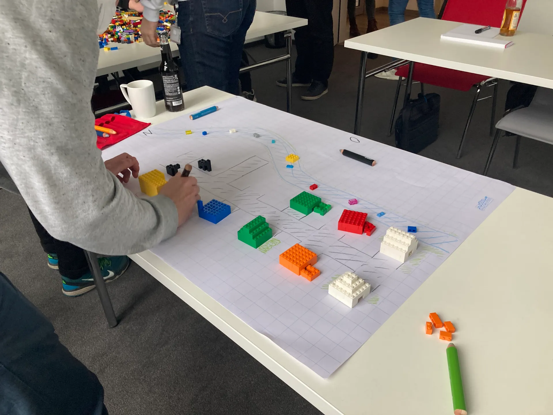 Ein Auszubildender beim Beschriften einer Skizze während des Scrum-Workshops