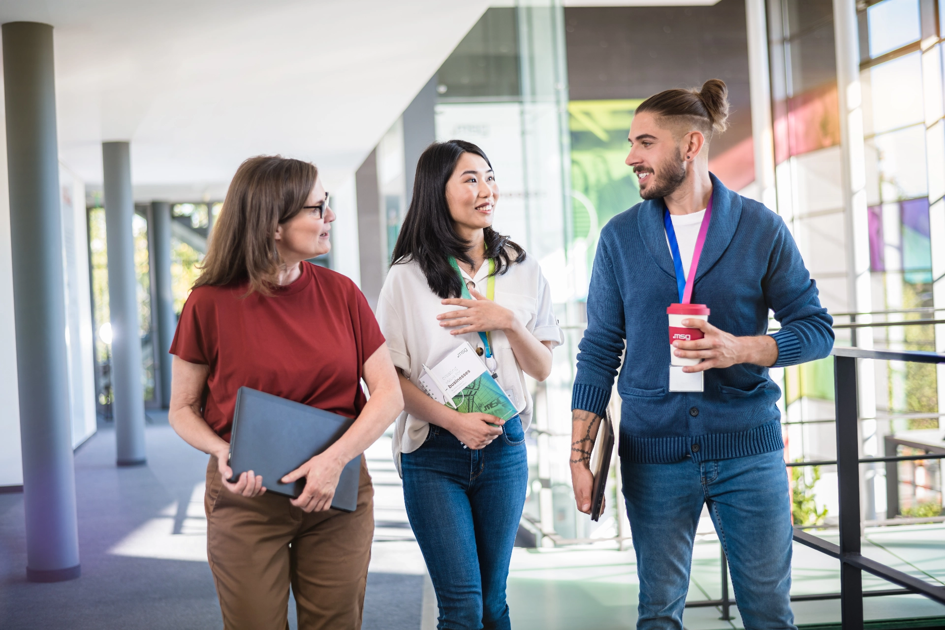 Eine gemischte Gruppe von msg-Mitarbeitenden in einem hellen Korridor am msg-Standort Ismaning